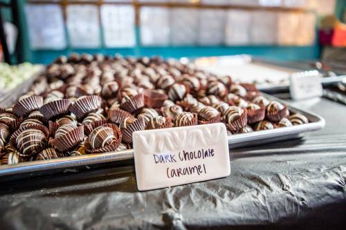 A tray of dark chocolate caramel candies, with a label in front identifying the treat.