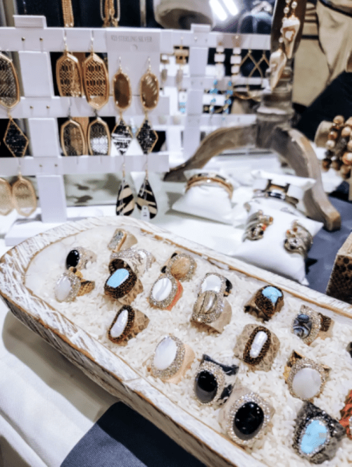 A display of various rings and earrings arranged on a table, showcasing intricate designs and materials.