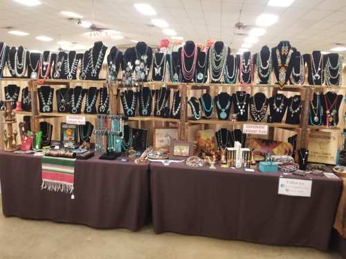 A display of various jewelry pieces on black busts and tables, featuring necklaces, bracelets, and decorative items.