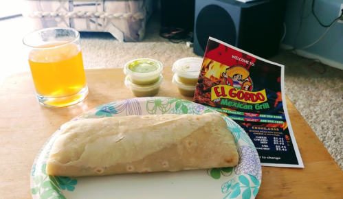 A plate with a burrito, three sauce containers, a drink, and a menu from El Gordo Mexican Grill on a table.