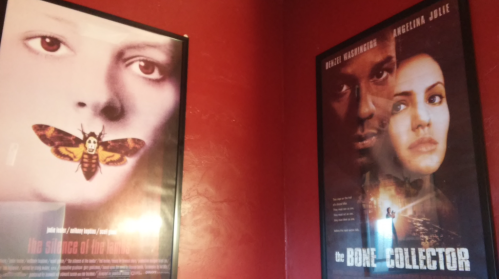 Two movie posters on a red wall: "The Silence of the Lambs" and "The Bone Collector."