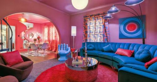 interior of a funky 1960s style living room withbright colors, a curved blue couch, hand chair, and more in lincoln nebraska
