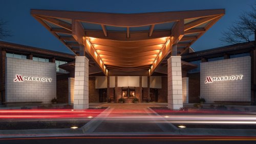 Marriott hotel entrance at dusk, featuring a modern design and illuminated signage.