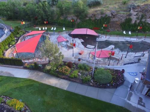 Aerial view of a park featuring red canopies, a water area, and landscaped gardens with pathways.