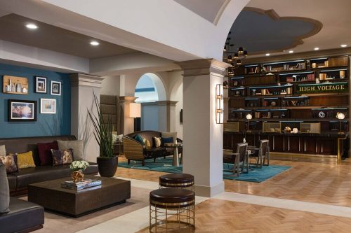 Modern lobby with stylish seating, decorative shelves, and a cozy atmosphere, featuring warm lighting and elegant decor.
