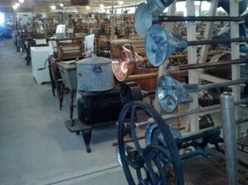 A vintage store interior filled with various antique items, including washing machines and metal containers.