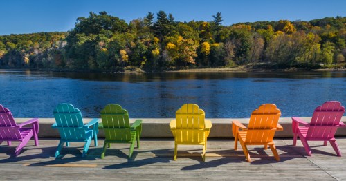 Kennebec River in Hallowell, Maine with colorful Adirondack chairs in the foreground.