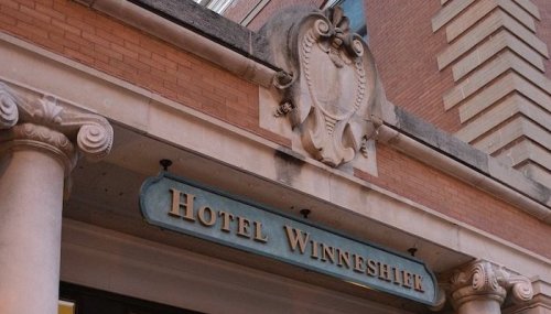 Sign for Hotel Winneshiek, featuring decorative architectural elements and columns.