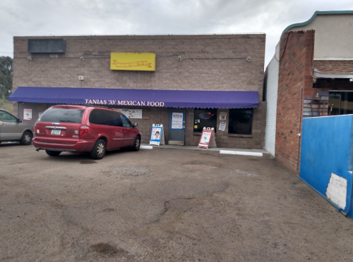 Exterior of Tania's 33 Mexican Food restaurant, featuring a purple awning and parked red minivan in front.