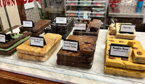 A display of various fudge flavors, including vanilla sea salt caramel, dark chocolate caramel toffee, and pumpkin pecan.