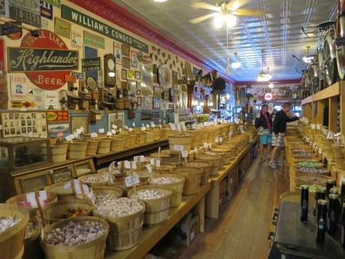 A vintage store interior filled with wooden baskets of candy and nostalgic memorabilia on the walls.