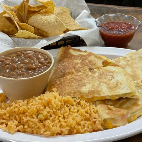 A plate of quesadillas with rice, beans, tortilla chips, and a small bowl of salsa.