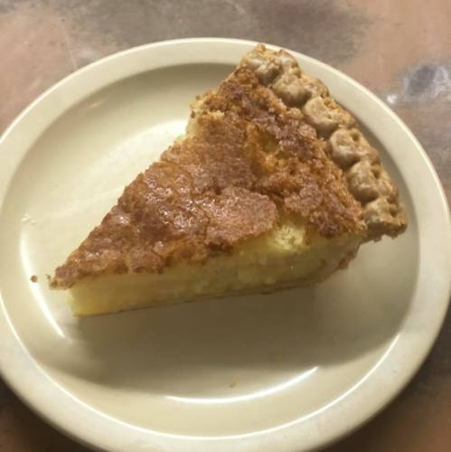 A slice of pie on a plate, featuring a golden-brown crust and a creamy filling.