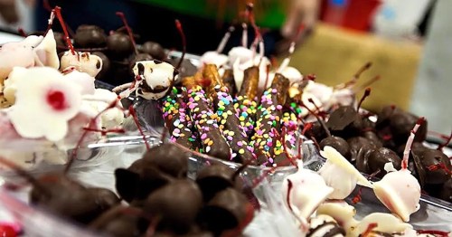 A colorful assortment of chocolate-covered treats, including cherries, pretzels with sprinkles, and white chocolate candies.