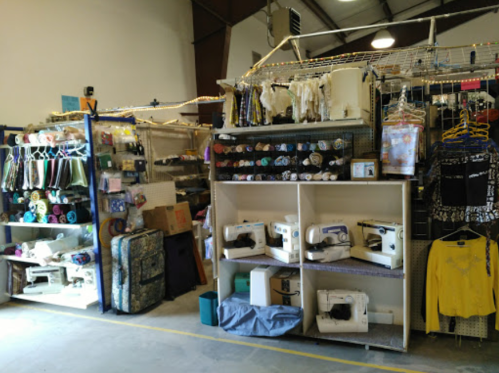 A craft store interior featuring shelves of fabric, sewing machines, and various sewing supplies.