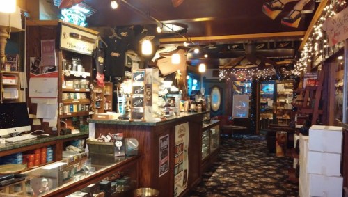 Cozy interior of a shop with wooden counters, shelves filled with products, and warm lighting.