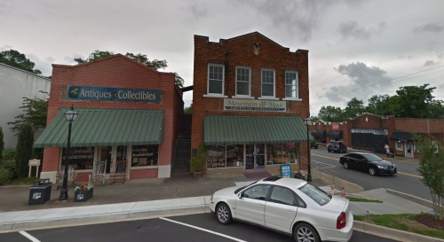 Two brick storefronts with green awnings, one labeled "Antiques & Collectibles" and the other "Mountain of Magic."
