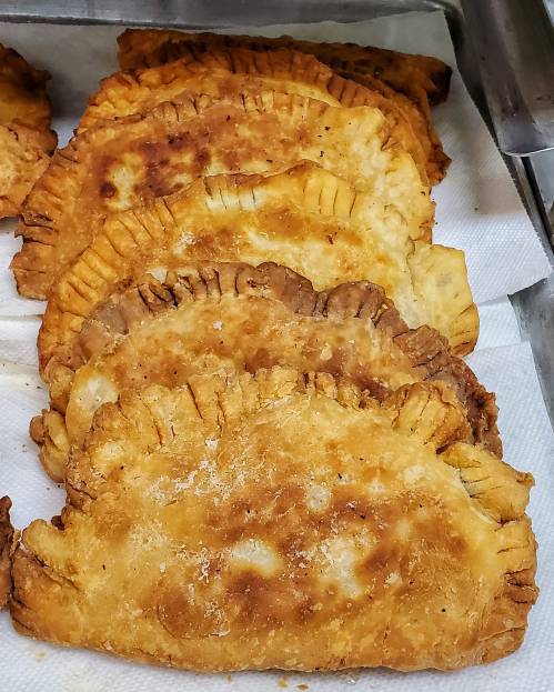 A stack of golden-brown, crispy fried pastries arranged neatly on a paper towel.
