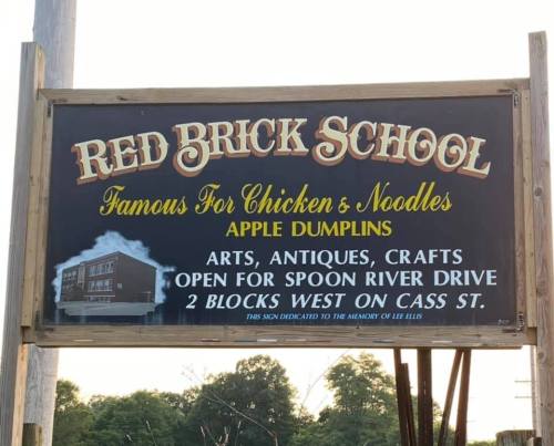 Sign for Red Brick School, advertising chicken and noodles, apple dumplings, and local arts and crafts.
