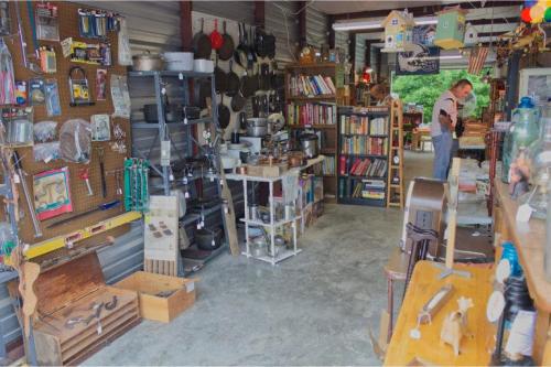 A cozy shop filled with various kitchenware, books, and vintage items, with a customer browsing in the background.