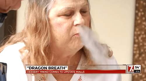 A woman experiences "Dragon Breath," a dessert trend, as vapor escapes her mouth.