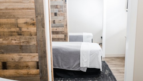 A cozy room with two beds, featuring wooden walls and a modern, minimalist design.
