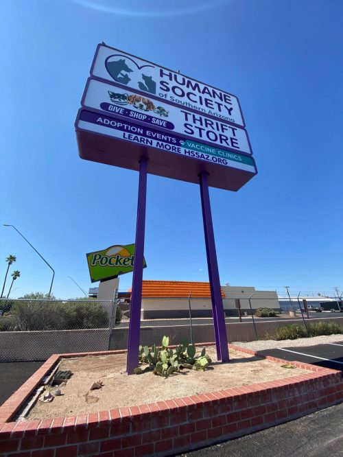 Sign for the Humane Society of Southern Arizona Thrift Store, promoting adoption, events, and vaccine clinics.