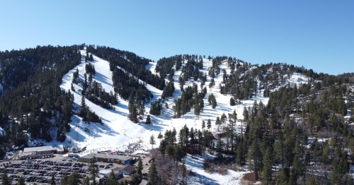 a snowy mountain with winter trees in the overlooked town of wrightwood, california