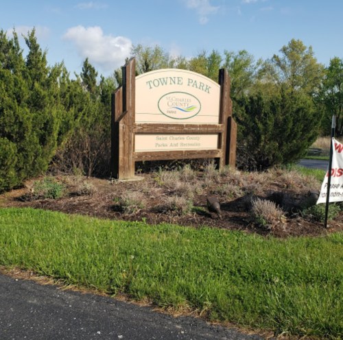 Sign for Towne Park in St. Charles County, surrounded by greenery and a clear blue sky.