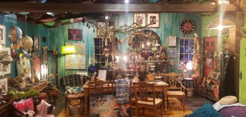 A cozy, eclectic room filled with colorful decor, plants, and unique furniture, creating a whimsical atmosphere.