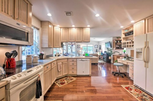 Bright, spacious kitchen with wooden cabinets, modern appliances, and a cozy dining area in an open layout.