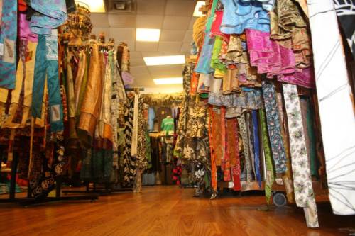 A vibrant clothing store aisle filled with colorful fabrics and garments hanging on racks.
