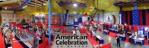 A spacious event hall decorated with gold streamers, featuring booths and displays for the "American Celebration on Parade."