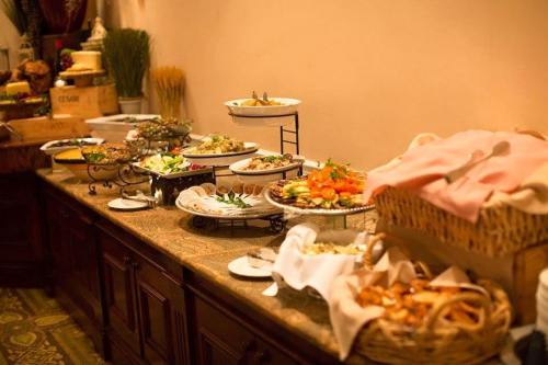 A buffet table featuring a variety of dishes, including salads, appetizers, and desserts, elegantly arranged.