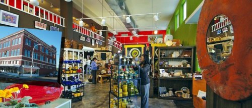 A vibrant store interior filled with colorful crafts, art, and local products, showcasing a welcoming atmosphere.