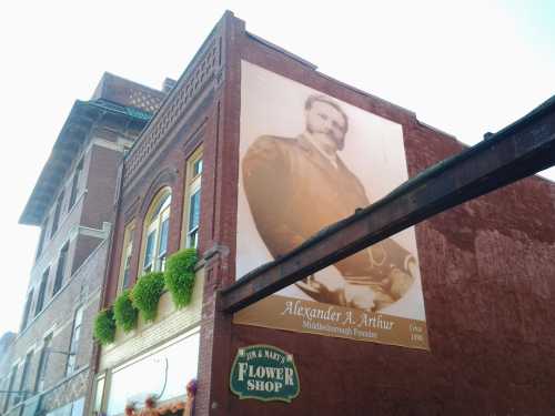 Mural of Alexander A. Arthur, founder of Middlesborough, on a brick building above a flower shop.