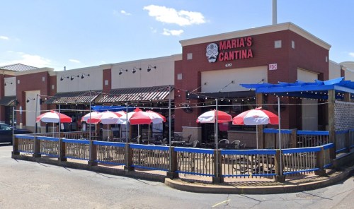 Exterior of Maria's Cantina featuring outdoor seating with umbrellas and a vibrant blue awning on a sunny day.