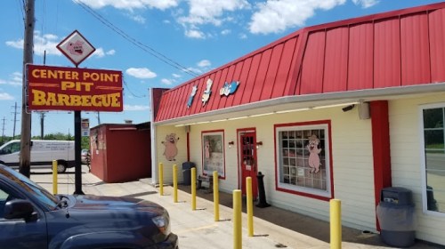 Exterior of Center Point Pit Barbecue, featuring a red roof, signage, and a bright, inviting facade.