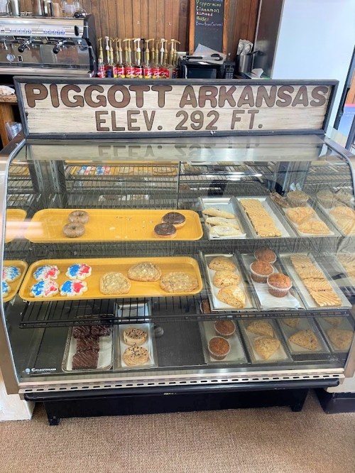 Display case filled with various baked goods, including cookies and pastries, in a shop in Piggott, Arkansas.