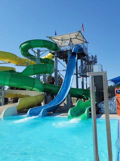 A water park featuring colorful slides and a pool under a clear blue sky.