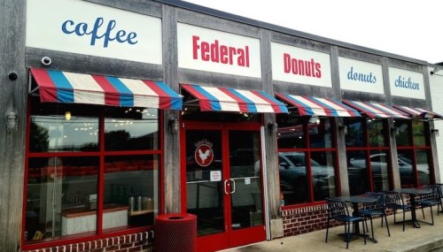 Exterior of Federal Donuts, featuring red and blue striped awnings, with signs for coffee, donuts, and chicken.
