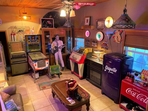 A retro-themed room featuring vintage decor, a jukebox, pinball machine, and classic soda machines.