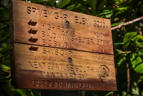 Wooden trail sign with directions and distances to High Rocks, Bald Mtn Shelter, Big Bald, and Sam's Gap.