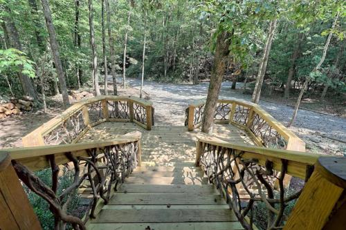 Wooden staircase with decorative railings leads down into a lush, green forested area.