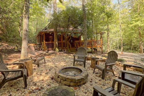 A cozy log cabin surrounded by trees, with a fire pit and seating area in a serene forest setting.