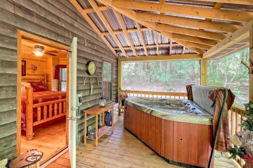 Cozy cabin interior with a hot tub, wooden decor, and a view of the surrounding greenery.