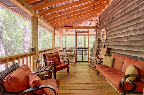 Cozy porch with wooden flooring, comfortable seating, and a view of trees, creating a relaxing outdoor space.