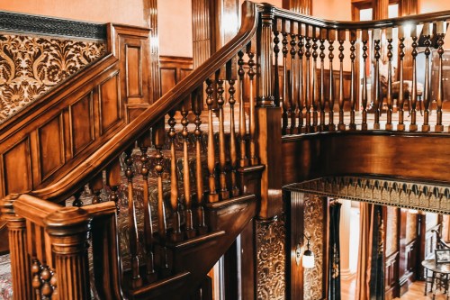 A beautifully crafted wooden staircase with intricate balusters in an elegant interior setting.
