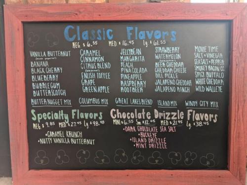 Chalkboard menu displaying ice cream flavors: classic, specialty, and chocolate drizzle options with prices.