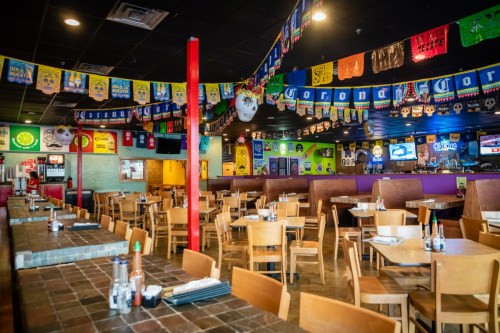 Colorful restaurant interior with festive decorations, empty tables, and a vibrant atmosphere.